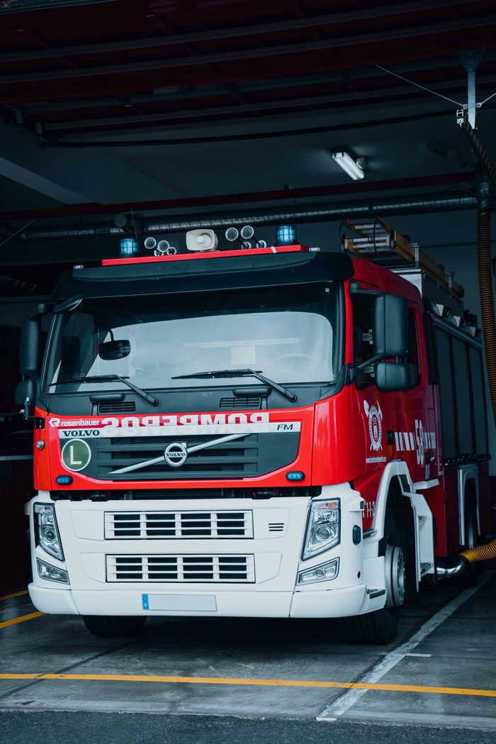 services-02 A red fire truck parked in a station garage, ready for action.